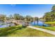 Picturesque lake view with a charming dock, lush greenery, and a pathway at 3823 N Oak Dr # K22, Tampa, FL 33611