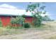 Exterior view of a red metal building surrounded by a dirt lot and trees at 3940 E Knights Griffin Rd, Plant City, FL 33565