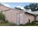 Exterior view of a pink metal building surrounded by a dirt lot and trees at 3940 E Knights Griffin Rd, Plant City, FL 33565