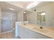 Bathroom featuring double sinks, a large mirror, and a glass-enclosed shower at 402 Laurel Lake Dr # 104, Venice, FL 34292