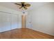 This bedroom features wood floors, a ceiling fan, and a closet for ample storage at 402 Laurel Lake Dr # 104, Venice, FL 34292