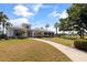 The clubhouse, with lush landscaping, American flag, and walkway leading to its entrance, exudes an inviting atmosphere at 402 Laurel Lake Dr # 104, Venice, FL 34292