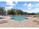 Refreshing community pool surrounded by ample seating, lounge chairs, and a secure fence at 402 Laurel Lake Dr # 104, Venice, FL 34292