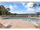 Community pool with lounge seating and picturesque views of the lake and surrounding trees at 402 Laurel Lake Dr # 104, Venice, FL 34292
