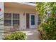 Charming condo entrance with a small seating area, well lit and landscaped at 402 Laurel Lake Dr # 104, Venice, FL 34292