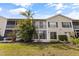 Exterior view of the condo building featuring multiple levels, patios, and lush landscaping at 402 Laurel Lake Dr # 104, Venice, FL 34292
