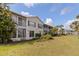 Exterior view of condo building set amidst well-manicured lawns, tropical foliage, and palm trees at 402 Laurel Lake Dr # 104, Venice, FL 34292