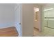 Hallway featuring access to bathroom and laundry room, along with hardwood floors at 402 Laurel Lake Dr # 104, Venice, FL 34292