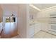 Bright kitchen featuring white cabinets and appliances overlooking the living area at 402 Laurel Lake Dr # 104, Venice, FL 34292