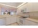Well-lit kitchen with ample countertop space and white appliances at 402 Laurel Lake Dr # 104, Venice, FL 34292