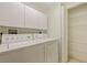 Laundry room with washer, dryer, storage cabinets, and wire shelving at 402 Laurel Lake Dr # 104, Venice, FL 34292