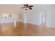 Living room with wood floors, ceiling fan, and view into the kitchen and hallways at 402 Laurel Lake Dr # 104, Venice, FL 34292