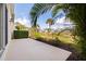 A concrete patio overlooks a pond with lush green surroundings, including palm trees at 402 Laurel Lake Dr # 104, Venice, FL 34292