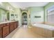 Bathroom featuring double vanity, a separate tub and a view into another room at 4094 Windcrest Dr, Wesley Chapel, FL 33544