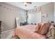 Bright bedroom with a ceiling fan, window, closet, and pink bedspread, complemented by charming decorations at 4094 Windcrest Dr, Wesley Chapel, FL 33544