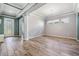 Spacious dining room with tray ceiling, wood-look tile floors, chandelier, and view to the entry door at 4094 Windcrest Dr, Wesley Chapel, FL 33544