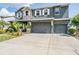 This two-story home features a three-car garage and manicured front lawn at 4094 Windcrest Dr, Wesley Chapel, FL 33544