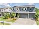 Beautiful two-story home with stone accents, a three-car garage, and well-manicured landscaping at 4094 Windcrest Dr, Wesley Chapel, FL 33544