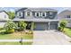 Charming two-story home featuring a three-car garage, stone accents, and lush landscaping at 4094 Windcrest Dr, Wesley Chapel, FL 33544