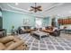 Open living room with wood flooring, ceiling fan, and view to the kitchen at 4094 Windcrest Dr, Wesley Chapel, FL 33544