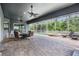 Spacious screened-in patio with brick flooring, ceiling fans, outdoor seating, and a luxurious pool at 4094 Windcrest Dr, Wesley Chapel, FL 33544