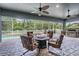 Covered patio featuring a ceiling fan, comfortable seating around a fire pit, and a scenic view of the pool at 4094 Windcrest Dr, Wesley Chapel, FL 33544