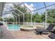 Screened-in pool and spa surrounded by brick pavers and a white picket fence provides a relaxing outdoor space at 4094 Windcrest Dr, Wesley Chapel, FL 33544
