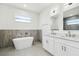 Bright bathroom features a soaking tub, double sink vanity, and contemporary fixtures at 4260 Baudelaire Ct, Brooksville, FL 34604