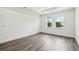 Bright bedroom with hardwood floors, clean white walls, and a view to the outdoors at 4260 Baudelaire Ct, Brooksville, FL 34604