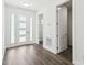 Bright foyer featuring a white door with windows, hardwood floors, and fresh, white walls at 4260 Baudelaire Ct, Brooksville, FL 34604