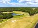 Scenic aerial view of a lush golf course with a tranquil pond and manicured greens, perfect for a relaxing day of golf at 4260 Baudelaire Ct, Brooksville, FL 34604