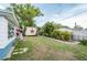 Grassy backyard with mature trees and storage shed at 4545 Annette St, New Port Richey, FL 34652