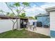 Backyard patio area with a grill, chairs, the AC unit, and part of the light blue home at 4545 Annette St, New Port Richey, FL 34652