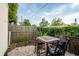 Backyard patio with pavers, a wooden table, four chairs, wooden fence, and leafy green plants at 4545 Annette St, New Port Richey, FL 34652