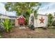 Backyard featuring a shed with a star, a chicken coop, tropical foliage and a large tree at 4545 Annette St, New Port Richey, FL 34652