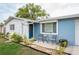 Welcoming blue exterior features a cozy seating area and meticulous landscaping. A great place to relax at 4545 Annette St, New Port Richey, FL 34652