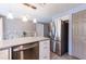 View of kitchen island, stainless steel appliances, and dining area with stone backsplash at 4545 Annette St, New Port Richey, FL 34652