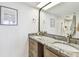 Spacious bathroom with dual sinks, granite countertops, decorative framed mirrors and framed artwork at 500 Treasure Island Cswy # 607, Treasure Island, FL 33706