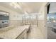 Elegant bathroom featuring granite counters, a large mirror, and glass-enclosed shower at 5005 Blue Latan Ln, Tampa, FL 33610