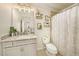 Elegant bathroom boasts a granite countertop vanity, decorative wall shelves, and a shower-tub combo at 5005 Blue Latan Ln, Tampa, FL 33610