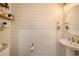 Stylish half bathroom with shiplap accent wall, modern fixtures, and pedestal sink at 5005 Blue Latan Ln, Tampa, FL 33610