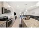 Open-concept kitchen featuring granite countertops, stainless steel appliances, and seamless flow to the living area at 5005 Blue Latan Ln, Tampa, FL 33610