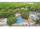 Aerial shot of the backyard featuring a blue roofed home, a sparkling blue pool, and ample tree coverage at 504 E Lee St, Plant City, FL 33563