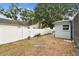 Fenced backyard with mature trees, landscaped perimeter, and lush lawn, providing a private outdoor sanctuary at 504 E Lee St, Plant City, FL 33563