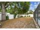 Fenced backyard with mature trees, landscaped perimeter, and lush lawn, providing a private outdoor sanctuary at 504 E Lee St, Plant City, FL 33563