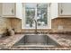Close-up of a kitchen sink featuring a stainless steel faucet and granite countertop at 504 E Lee St, Plant City, FL 33563