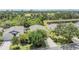 Aerial view of a property showcasing the home, lush landscaping, driveway, and adjacent pond at 5205 Lansdowne Way, Palmetto, FL 34221