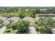 Aerial view of a property showcasing the home, lush landscaping, driveway, and adjacent pond at 5205 Lansdowne Way, Palmetto, FL 34221