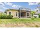 Exterior view of the rear of the home and a screened-in porch with manicured lawn at 5205 Lansdowne Way, Palmetto, FL 34221