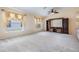 Spacious living room with large windows, neutral carpet, ceiling fan, and custom built-in entertainment center at 5205 Lansdowne Way, Palmetto, FL 34221